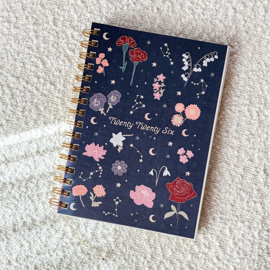 Notebook with floral and celestial design on a textured surface